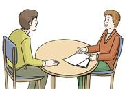 zwei Personen, die an einem Tisch sitzen und miteinander reden