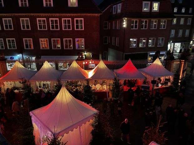 LWL-Landesdirektor Dr. Lunemann vor einem Weihnachtsmarktstand.