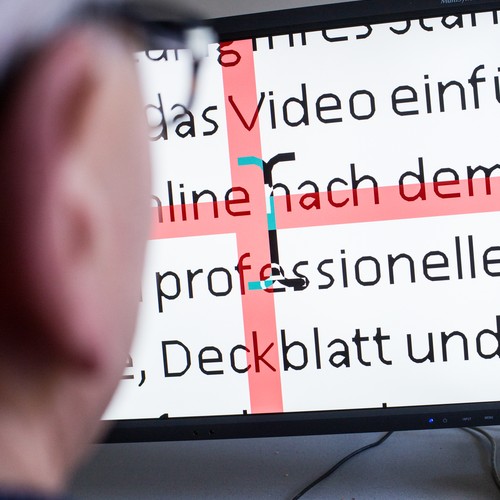 Eine Person schaut auf einen Computer-Bildschirm, der Schrift in starker Vergrößerung zeigt