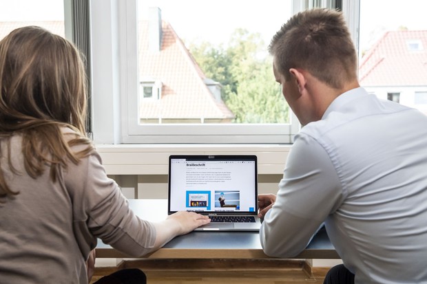 Eine Mann und eine Frau sitzen vor einem Laptop
