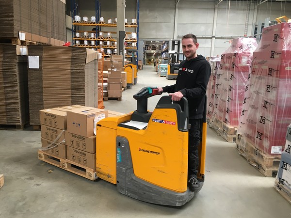 Ein junger Mann bedient einen Hubwagen