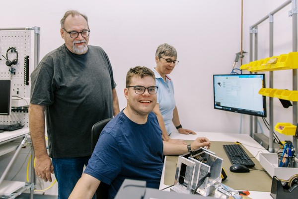 Johannes Krawinkel an seinem neuen Arbeitsplatz bei der Firma dSpace in Paderborn zusammen mit Jobcoach Jürgen Tölle.