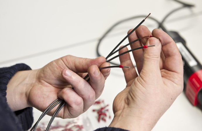 Zwei Hände halten Kabel in der Hand.